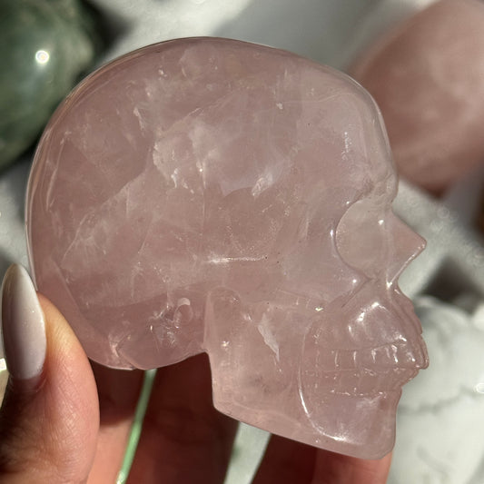 Skull Carving - Rose Quartz #10, side view showing translucent pale pink coloring.