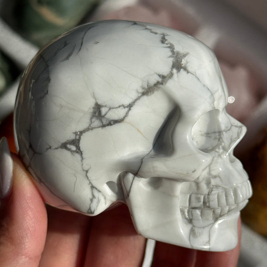 Skull Carving - Howlite #17, side view showing white coloring with gray branching veins.
