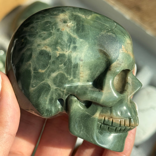 Skull Carving - Green Dragon Jasper #6, side view showing green coloring with cream and tan veining.