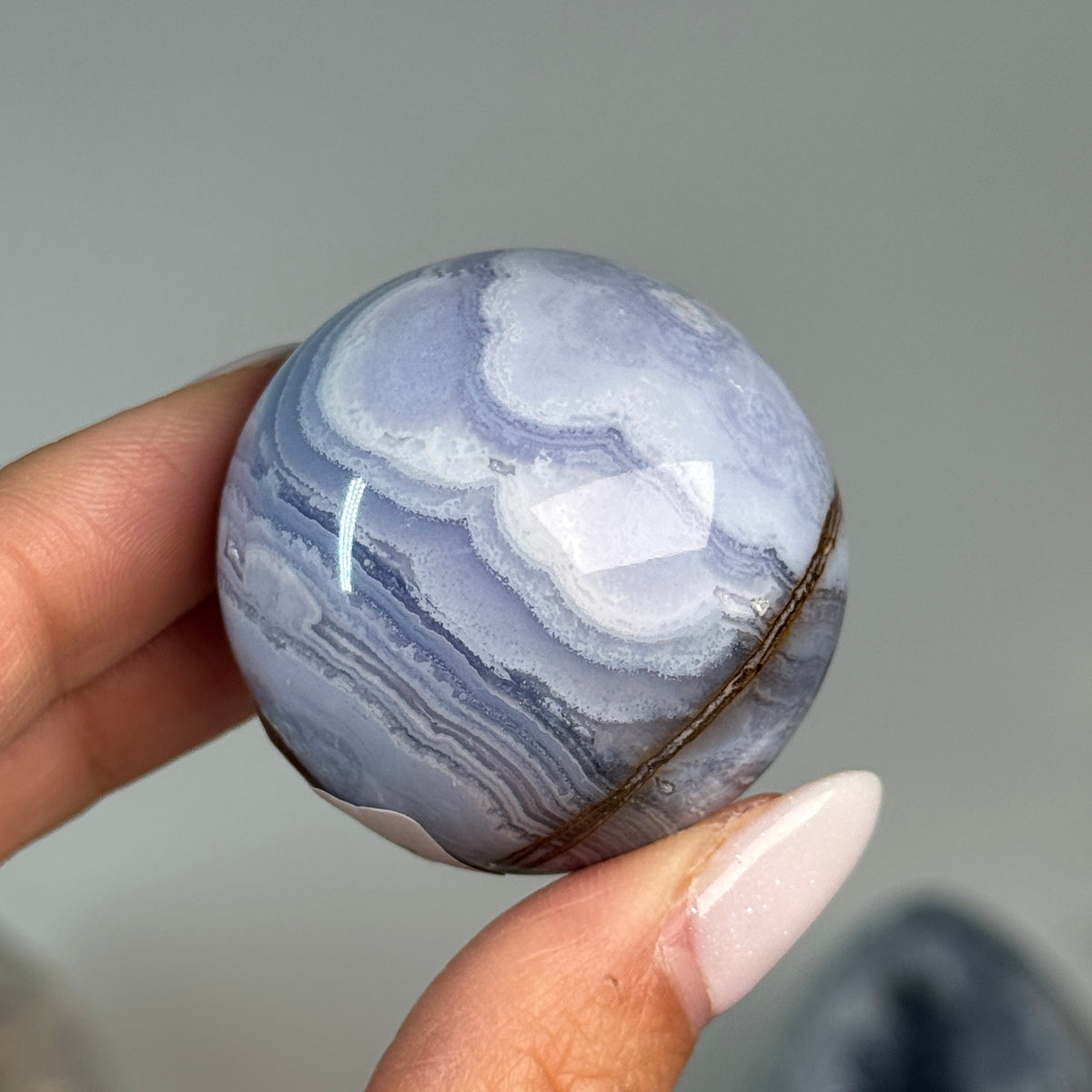 Blue Lace Agate Sphere #12, alternate view showing blue and white banding with a brown mineral seam.