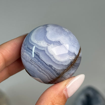 Blue Lace Agate Sphere #12, alternate view showing blue and white banding with a brown mineral seam.