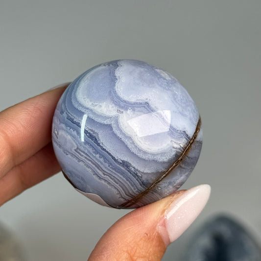 Blue Lace Agate Sphere #12, alternate view showing blue and white banding with a brown mineral seam.