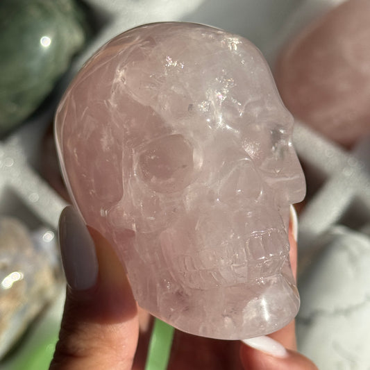 Skull Carving - Rose Quartz #10, front view showing translucent pale pink coloring.