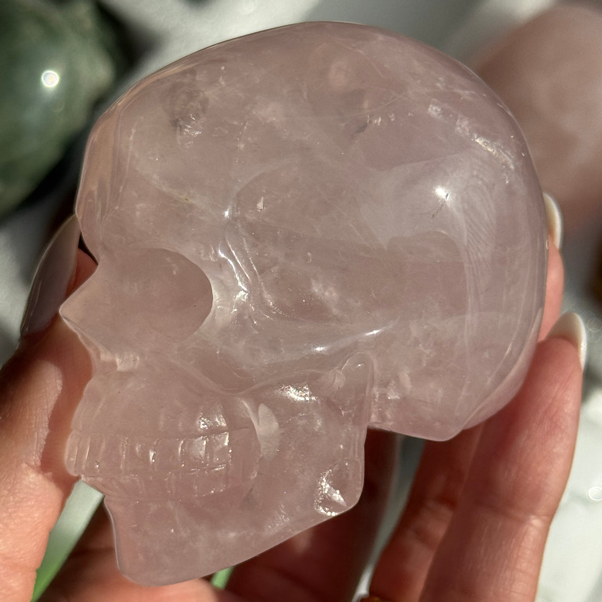 Skull Carving - Rose Quartz #10, opposite side view showing translucent pale pink coloring.