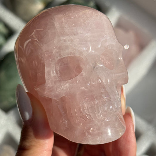 Skull Carving - Rose Quartz #11, front view showing pale pink coloring with cloudy white areas.
