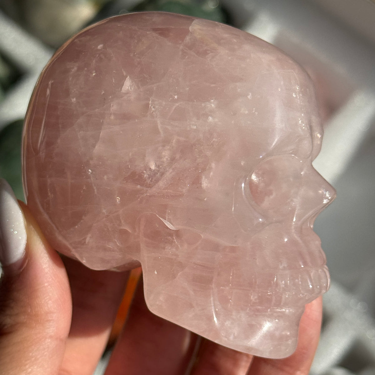 Skull Carving - Rose Quartz #11, side view showing pale pink coloring with cloudy white areas.