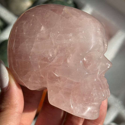 Skull Carving - Rose Quartz #11, side view showing pale pink coloring with cloudy white areas.