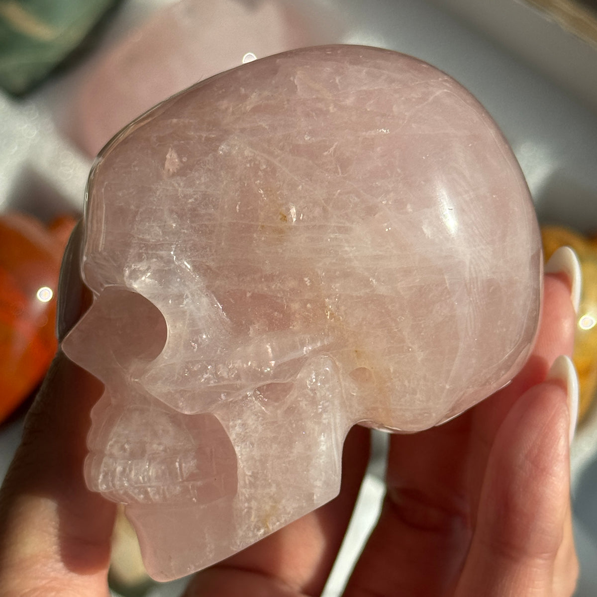 Skull Carving - Rose Quartz #11, opposite side view showing pale pink coloring with cloudy white areas.