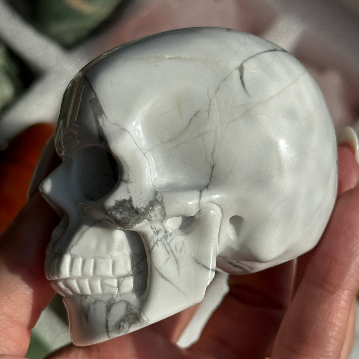 Skull Carving - Howlite #17, opposite side view showing white coloring with gray branching veins.