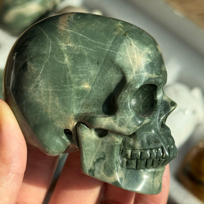 Skull Carving - Green Dragon Jasper #2, side view showing deep green coloring with pale mineral patches.