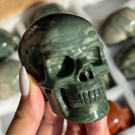 Skull Carving - Green Dragon Jasper #4, front view showing dark green coloring and pale curved bands.