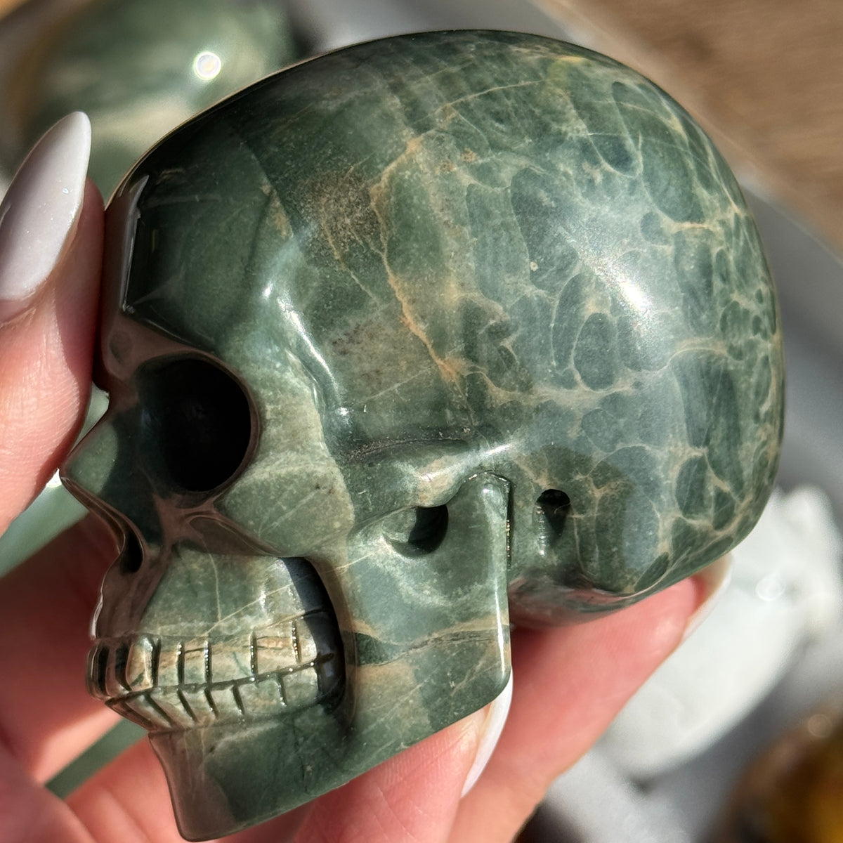 Skull Carving - Green Dragon Jasper #6, opposite side view showing green coloring with cream and tan veining.