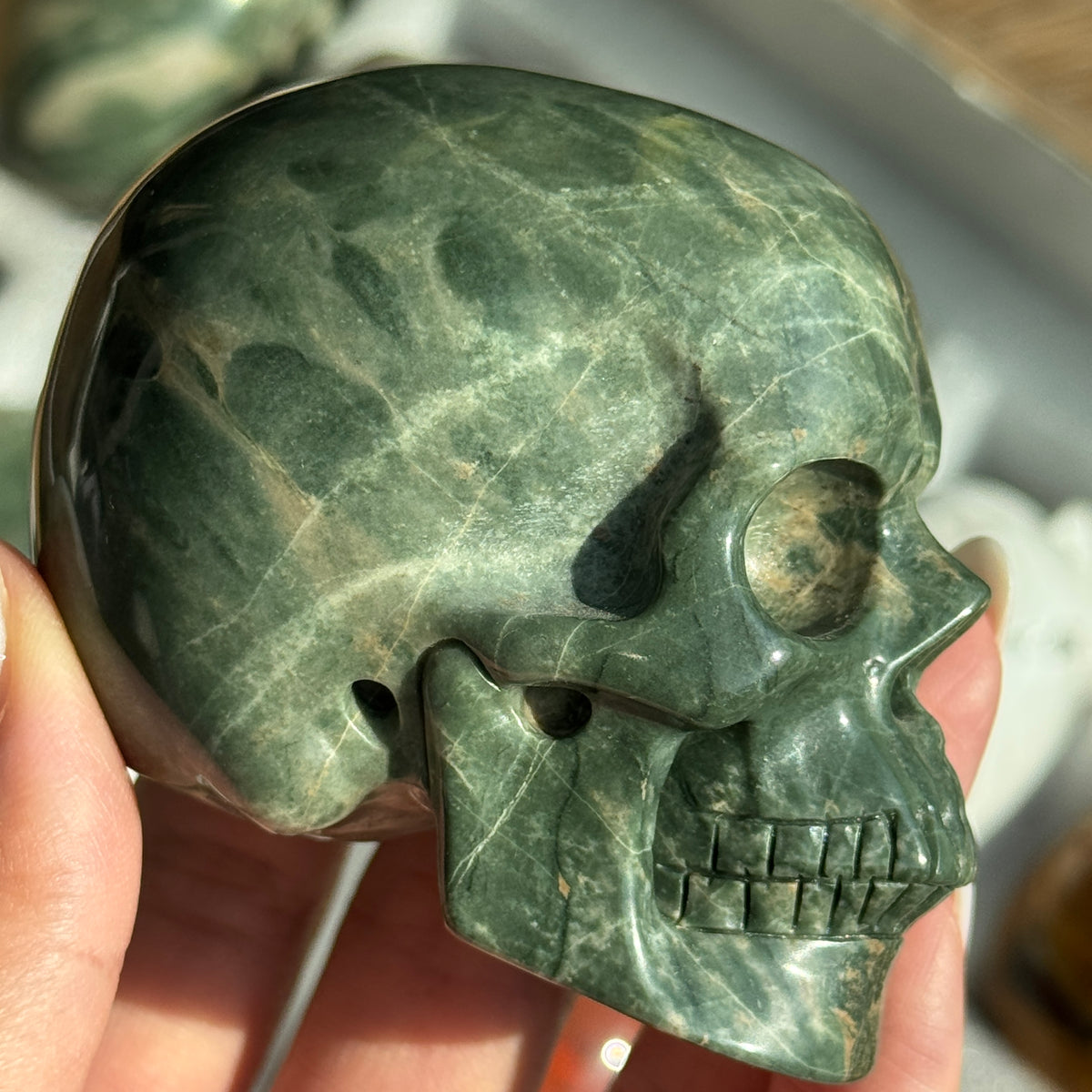 Skull Carving - Green Dragon Jasper #7, side view showing dark green and cream mottled patterns.