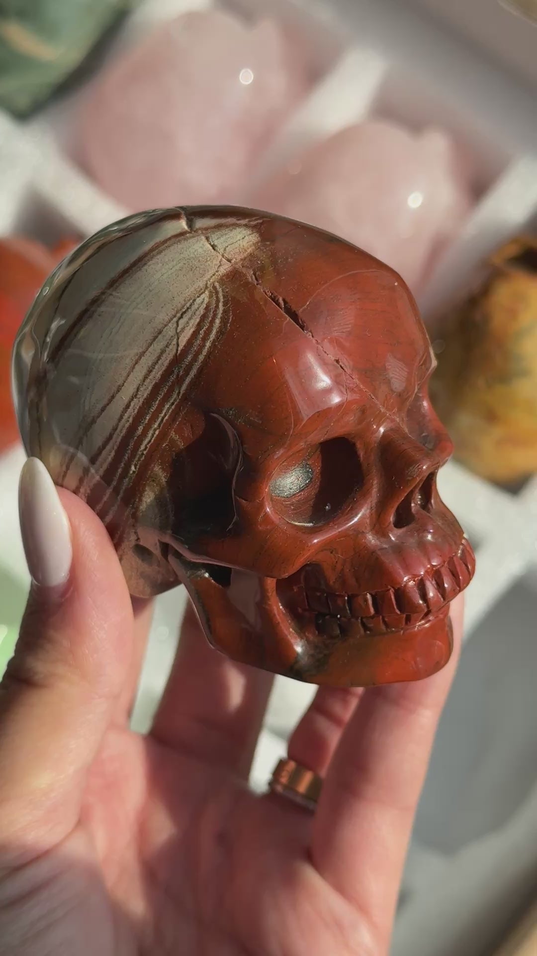 Video of Skull Carving - Red Jasper #15, showing the carved details and rust-red coloring with cream and gray banding.