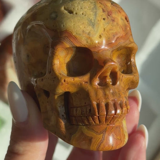Video of Skull Carving - Crazy Lace Agate #12, showing the carved details and golden-brown, cream and dark lace-like banding.