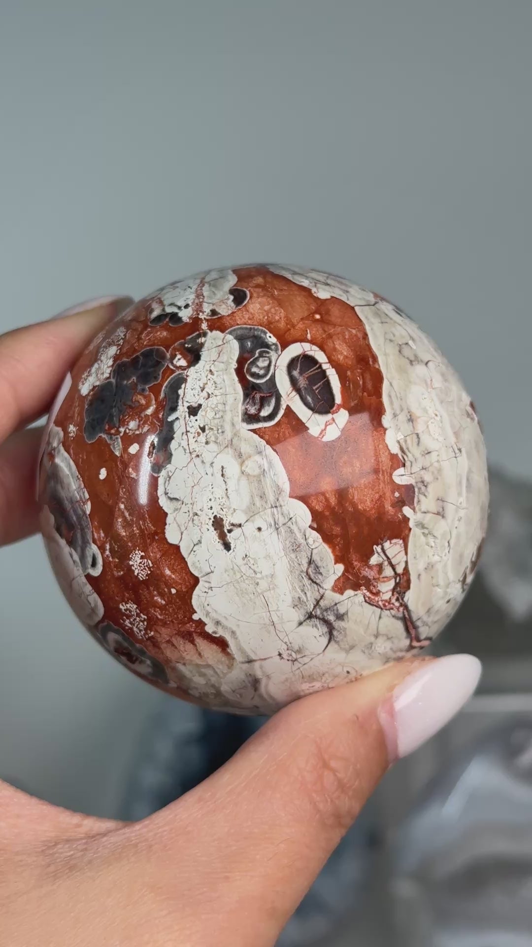 Video of Money Agate Sphere #1, showing rust-red, cream and dark orbicular patterns across the polished sphere.