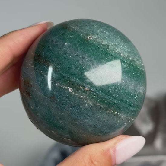 Video of Teal Aventurine Sphere #2, showing teal-green coloring with brown patches across the polished sphere.
