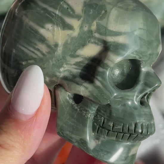 Video of Skull Carving - Green Dragon Jasper #4, showing the carved details and dark green coloring and pale curved bands.