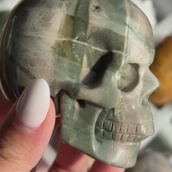 Video of Skull Carving - Green Dragon Jasper #1, showing the carved details and gray-green coloring with broad pale bands.