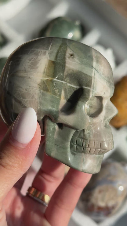 Video of Skull Carving - Green Dragon Jasper #1, showing the carved details and gray-green coloring with broad pale bands.