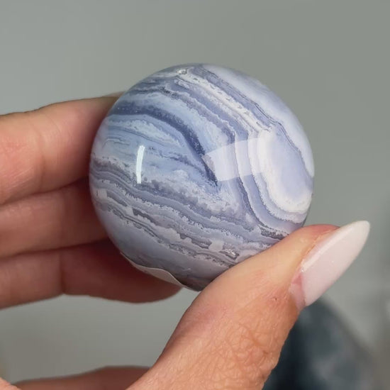 Video of Blue Lace Agate Sphere #12, showing blue and white banding with a brown mineral seam across the polished sphere.