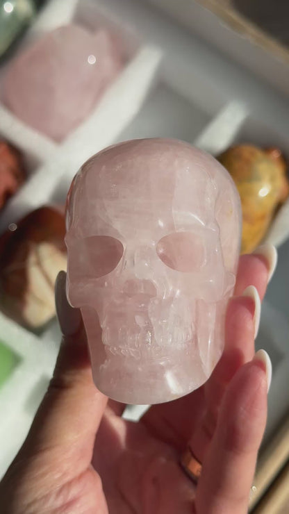 Video of Skull Carving - Rose Quartz #11, showing the carved details and pale pink coloring with cloudy white areas.