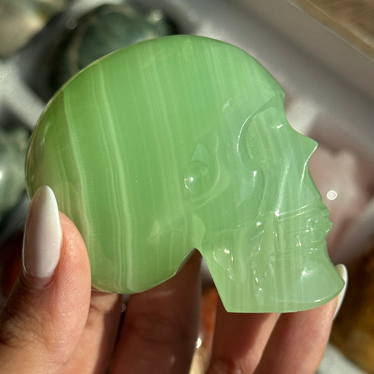 Skull Carving - HQ Green Onyx, front view showing translucent bright green coloring and pale bands.